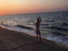Milf con botín desnudo nadando en el mar al atardecer
