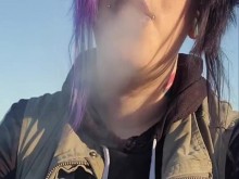 Chica alternativa fumando cigarrillos en la playa.